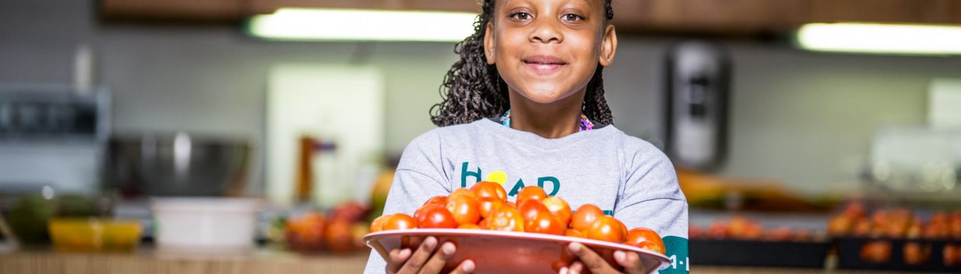 Young 4-H member holding a bowl of cherry tomatoes