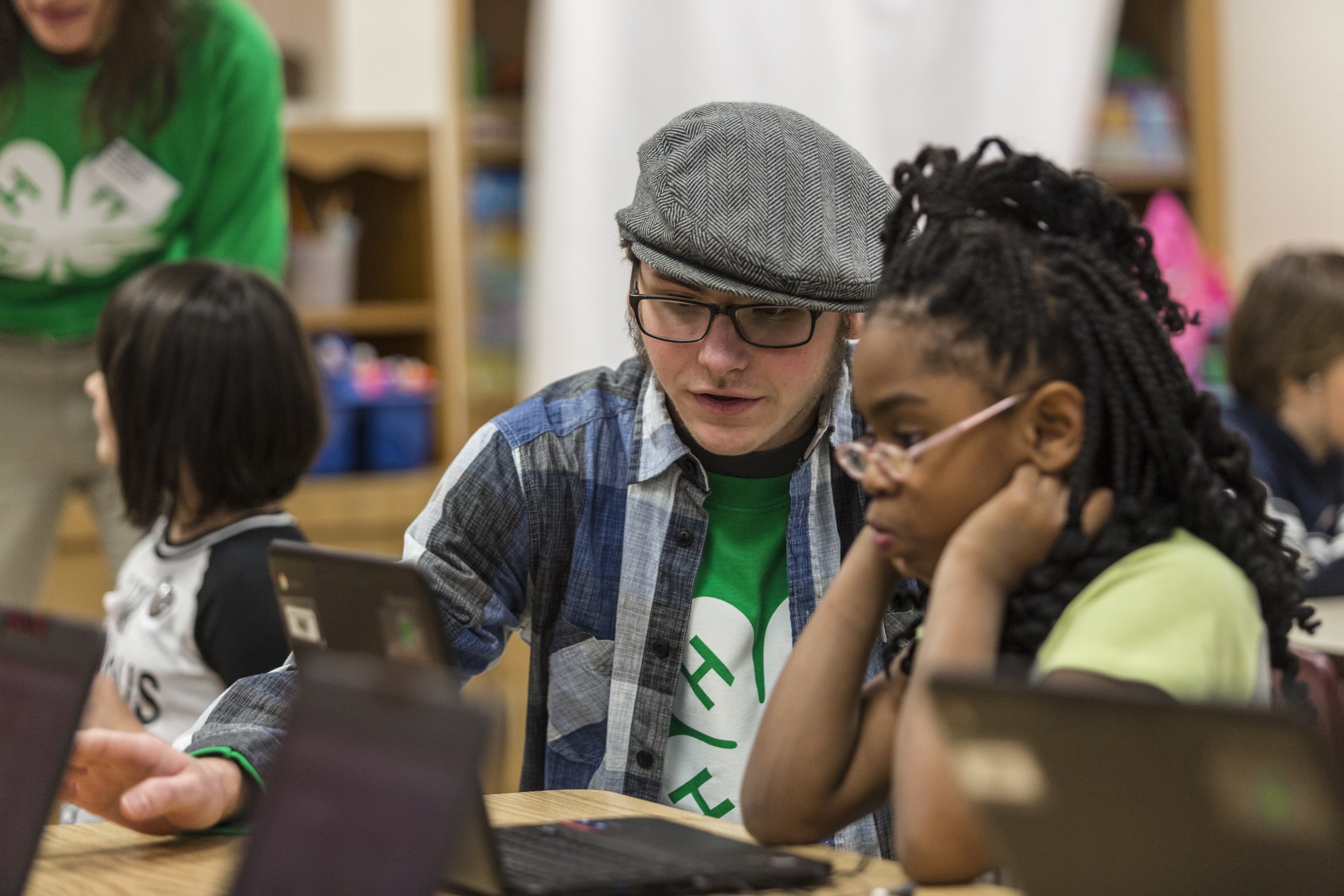 A 4-H educator shows a young girl something on the computer