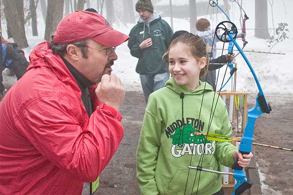 Archery instructor giving youth tips