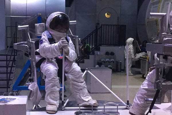 4-H youth in space suit in a simulator environment