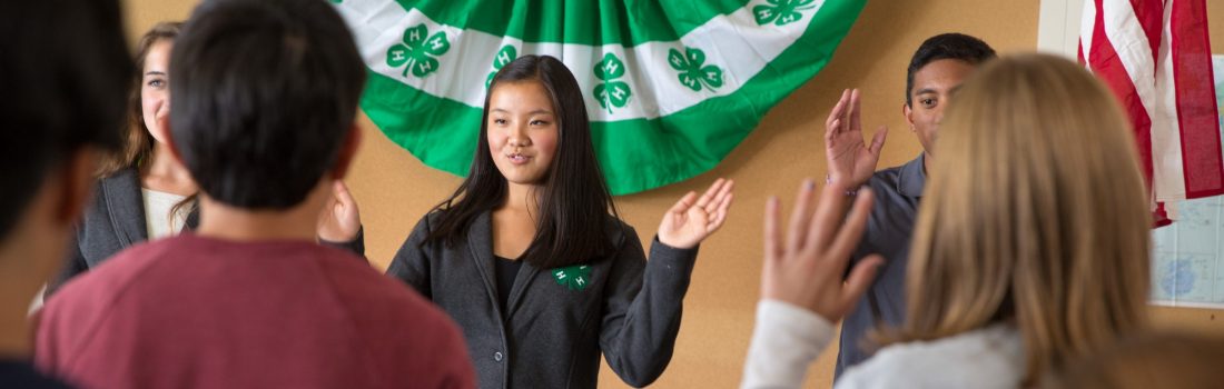 Youth reciting 4-H pledge at meeting