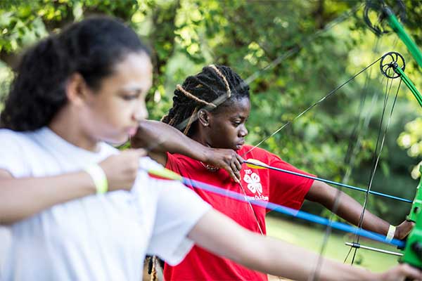 Two young women competing in archery