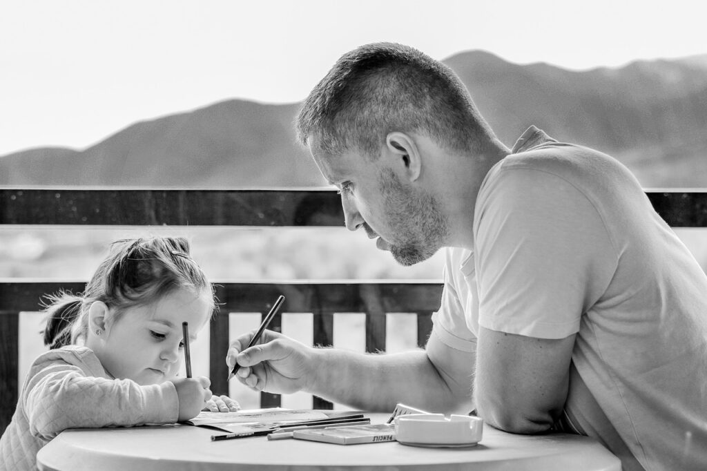 Adult man and child drawing together