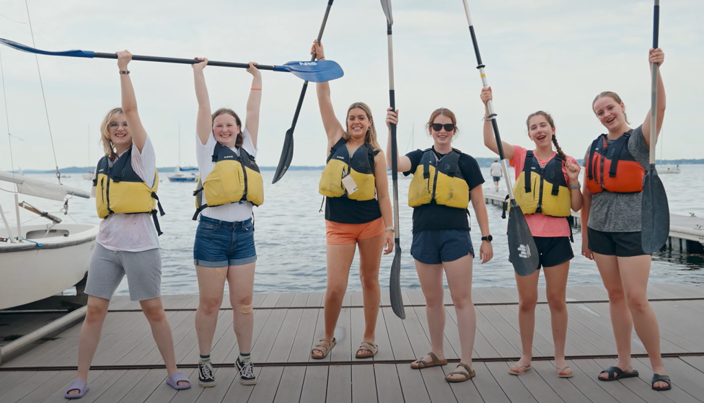 Six Wisconsin 4-H Summer Academy Attendees pose with their paddles before paddleboarding on Lake Mendota.