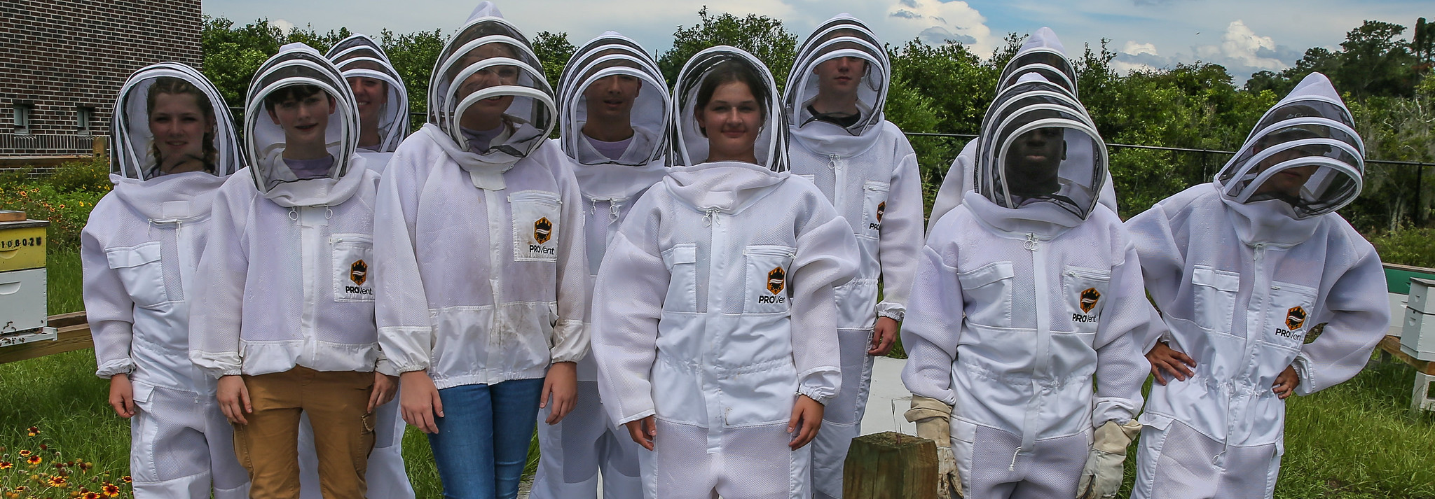 group of youth wearing bee suits