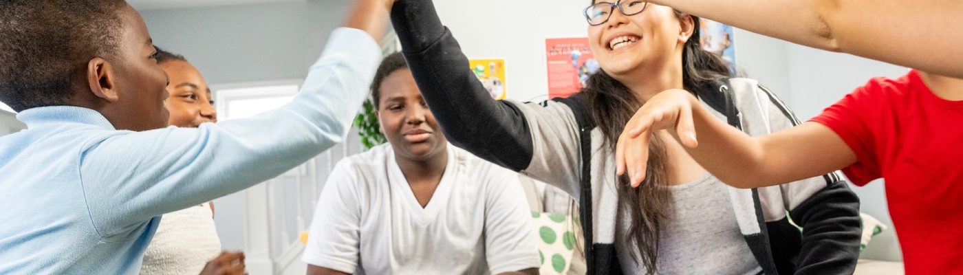 Youth high-fiving over a board game