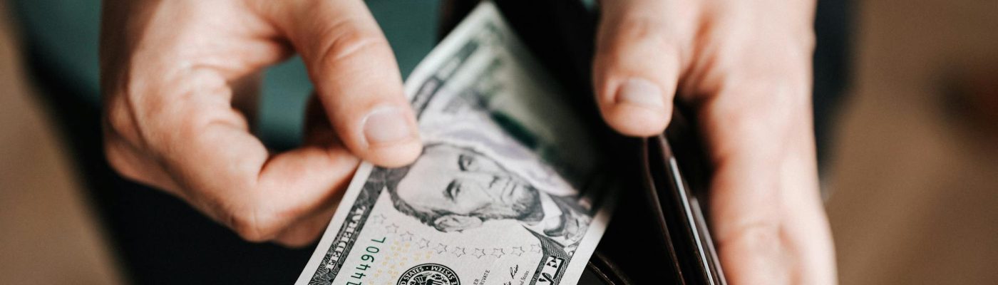 Teen pulling a five dollar bill from a wallet