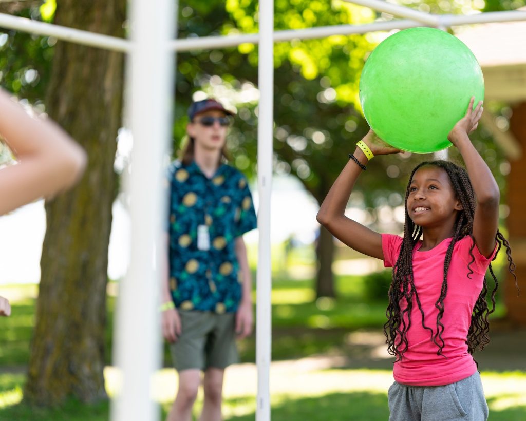 youth playing with a big green ball