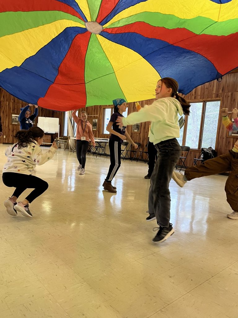 Youth playing under a parachute at ArtBEAT!