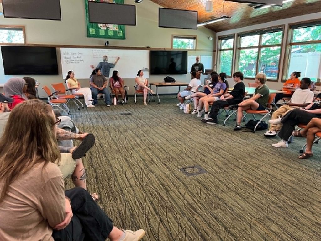 Youth and adults gather in a circle to discuss plans for the Youth as Partners in Civic Leadership Conference 2026.