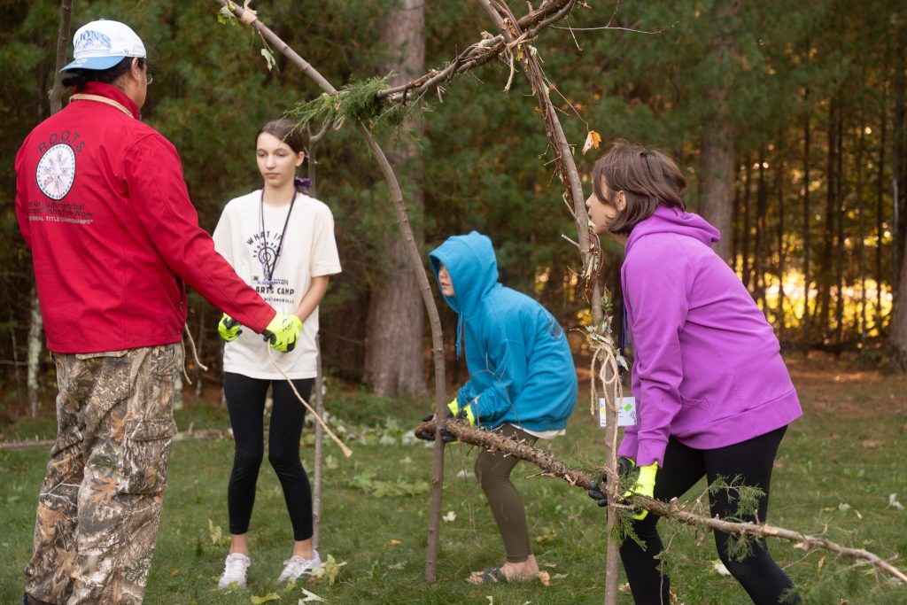 Arts Camp attendees build a lodge with Shane Funmake.